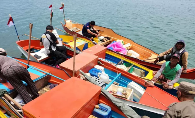 DIPULANGKAN: Tim saat memeriksa kondisi perahu yang digunakan 11 nelayan asal Malaysia, di dermaga Tanjung Batu. Sebelum dipulangkan, nelayan asing tersebut diberi bekal makanan dan minuman.