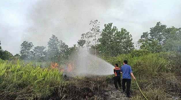 PADAMKAN: Petugas Damkar BPBD Berau saat berusaha memadamkan kebakaran lahan di Jalan Jendral Gatot Subroto, Tanjung Redeb, Kamis (13/10).