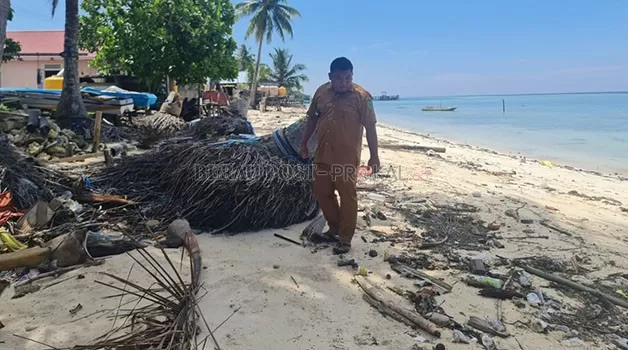MULAI TERKIKIS: Aparat Kampung Payung-Payung menunjukkan kawasan pantai yang terus terkikis abrasi.