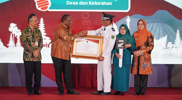 BUAH KERJA KERAS: Kepala Kampung Sumber Agung Edi Santoso, menerima penghargaan usai menjadi yang terbaik dalam Lomba Desa Tingkat Nasional Regional III, di Jakarta, Kamis (24/11).