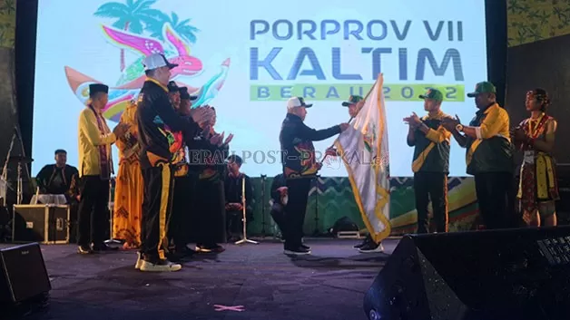 BENDERA ESTAFET: Bupati Paser Fahmi Fadli, saat menerima bendera estafet sebagai tuan rumah Porprov VIII Kaltim 2026, yang diserahkan oleh Gubernur Kaltim Isran Noor, pada acara closing ceremony Porprov VII Kaltim di Berau, kemarin (7/12) malam.