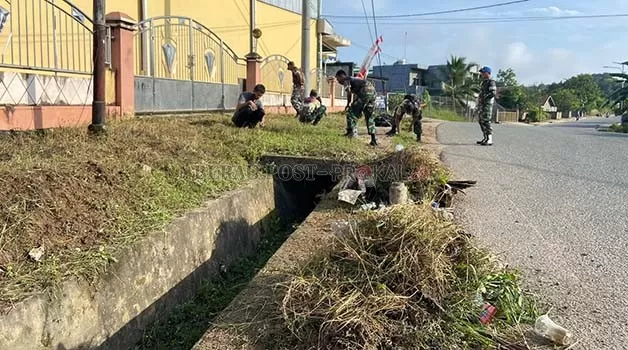 BERSIH-BERSIH: Personel Kodim 0902/BRU bersama masyarakat dan jajaran Polri, membersihkan drainase dan memotong rumput liar di Jalan Pulau Panjang, Jumat (13/1).