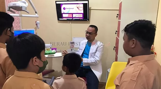 BERI PENJELASAN: Owner DentSmart Dental Care Specialist, drg Rustan Ambo Asse, memberikan penjelasan langsung kepada pelajar SD Annisa tentang pentingnya menjaga kesehatan gigi.