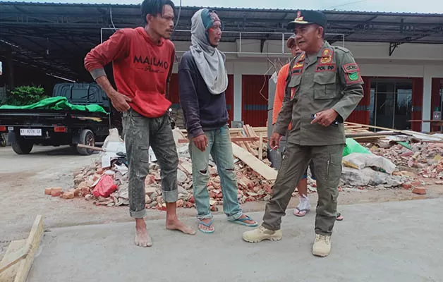 BERI TEGURAN: Kepala Satpol PP Berau Anang Saprani menegur pekerja bangunan, karena menempatkan material bangunan di badan jalan.