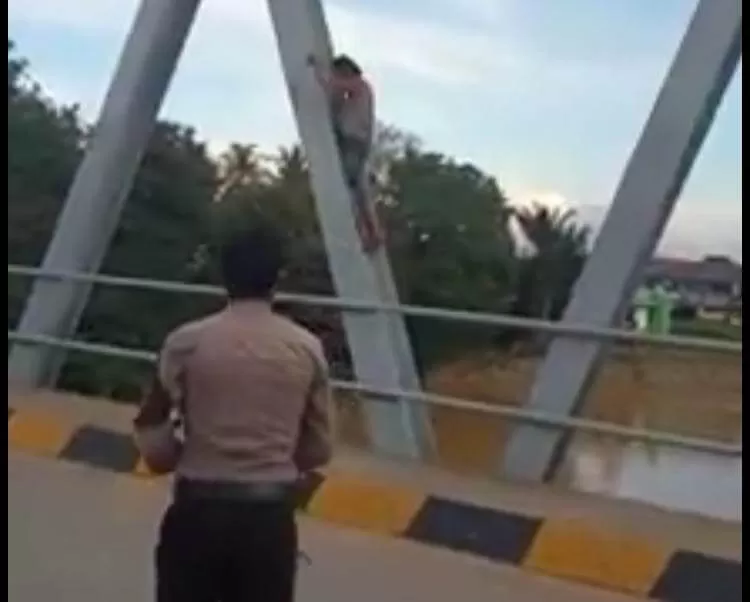 Cuplikan video viral seorang anggota Polsek Ngabang merayu ODGJ agar turun dari jembatan Ngabang, Jumat (15/5). foto Istimewa