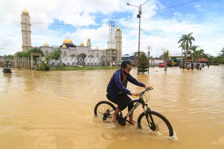 Seorang pesepeda melintasi jalan raya yang terendam banjir, di Kota Putussibau, Kabupaten Kapuas Hulu, Kalimantan Barat, Senin (14/9/2020). Banjir yang melanda Putussibau secara merata sejak Minggu (14/9/2020) kemarin tersebut terjadi akibat tingginya curah hujan selama beberapa hari terakhir hingga melumpuhkan aktifitas masyarakat di kota setempat. ANTARA FOTO/Jessica Helena Wuysang/hp.