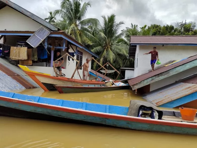 Warga meninggalkan rumahnya karena tinggi air telah mencapai atap di Kecamatan Kuala Behe, Sabtu (16/1). Foto Istimewa