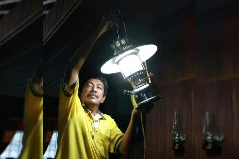 PETROMAK: Seorang lelaki hendak menggantung lampu petromak usai menyalakannya. Lampu yang oleh masyarakat Kalbar disebut serongkeng tersebut lazim digunakan sebagai penerangan di desa-desa yang belum teraliri listrik. PAGE FACEBOOK ARAHMAN OMAN