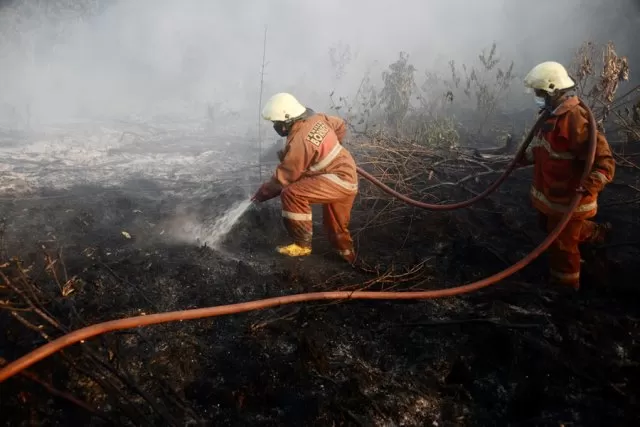 KEBAKARAN GAMBUT: Petugas Pemadam kebakaran swasta sedang membasahi lahan gambut yang terbakar di Jalan Sepakat 2, Pontianak Tenggara, kemarin. ARIEF NUGROHO/PONTIANAK POST