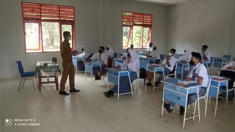 MENGAJAR: Tolhah, seorang guru honorer saat mengajar di SMA Negeri 1 Serasan Timur, Kabupaten Natuna, Kepulauan Riau, belum lama ini. ISTIMEWA