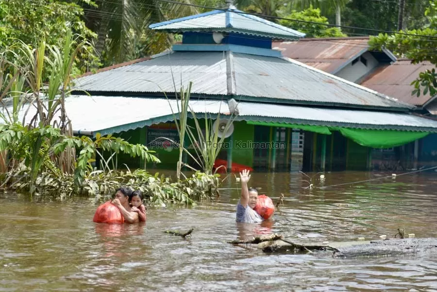 BANJIR TERPARAH: Sejumlah warga melewati Jalan Lintas Melawi yang terendam banjir sejak 24 Oktober hingga akhir November 2021. Banjir di Sintang ini disebut-sebut sebagai banjir yang terparah sejak tahun 1960-an. Selama 2021, bencana tak henti-hentinya melanda Kalbar.