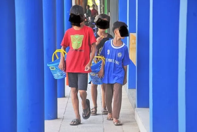 BERJUALAN KUE: Anak-anak membawa keranjang yang berisikan dagangan kue saat berkeliling di sekitar Jalan Pattimura. Aktivitas itu mereka lakoni di sela rutinitas sekolah mereka. HARYADI/PONTIANAK POST
