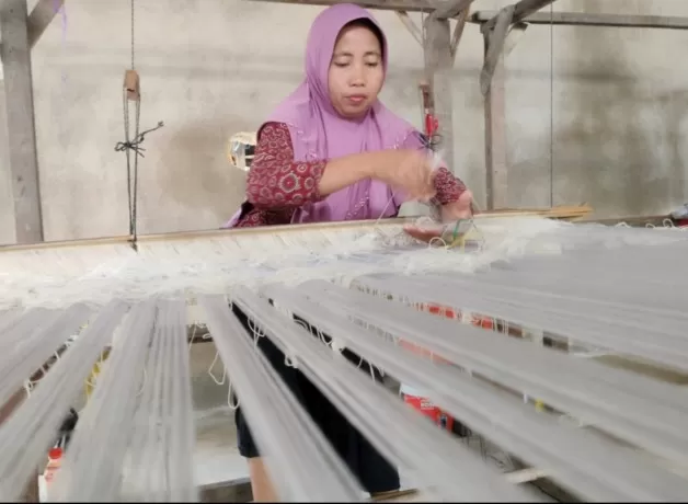 MENENUN: Kurniati (44) sedang menenun kain songket di pabrik mini di belakang rumahnya, Gang Sambas Jaya, Batulayang, Pontianak Utara.
