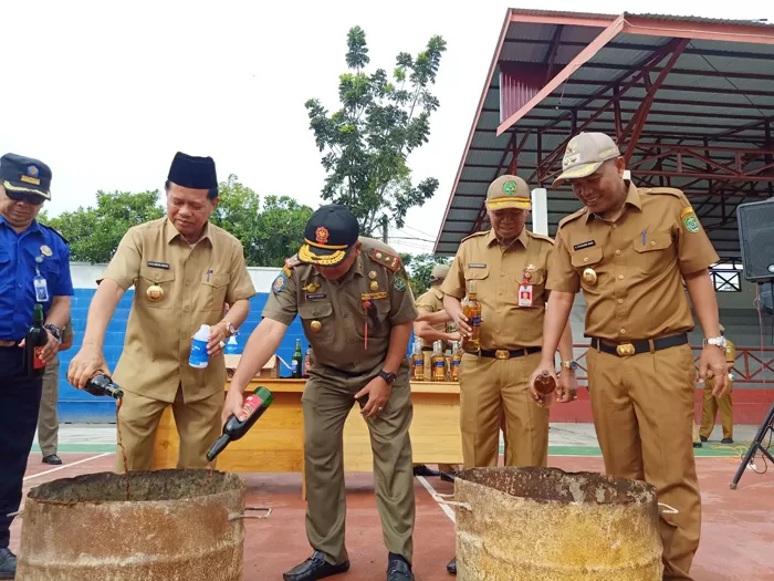 TERLALU RINGAN: Bupati Tapin, M Arifin Arpan bersama jajaran memusnahkan barang bukti minuman keras dan alkohol, Senin (6/1). | Foto: Rasidi Fadli/Radar Banjarmasin