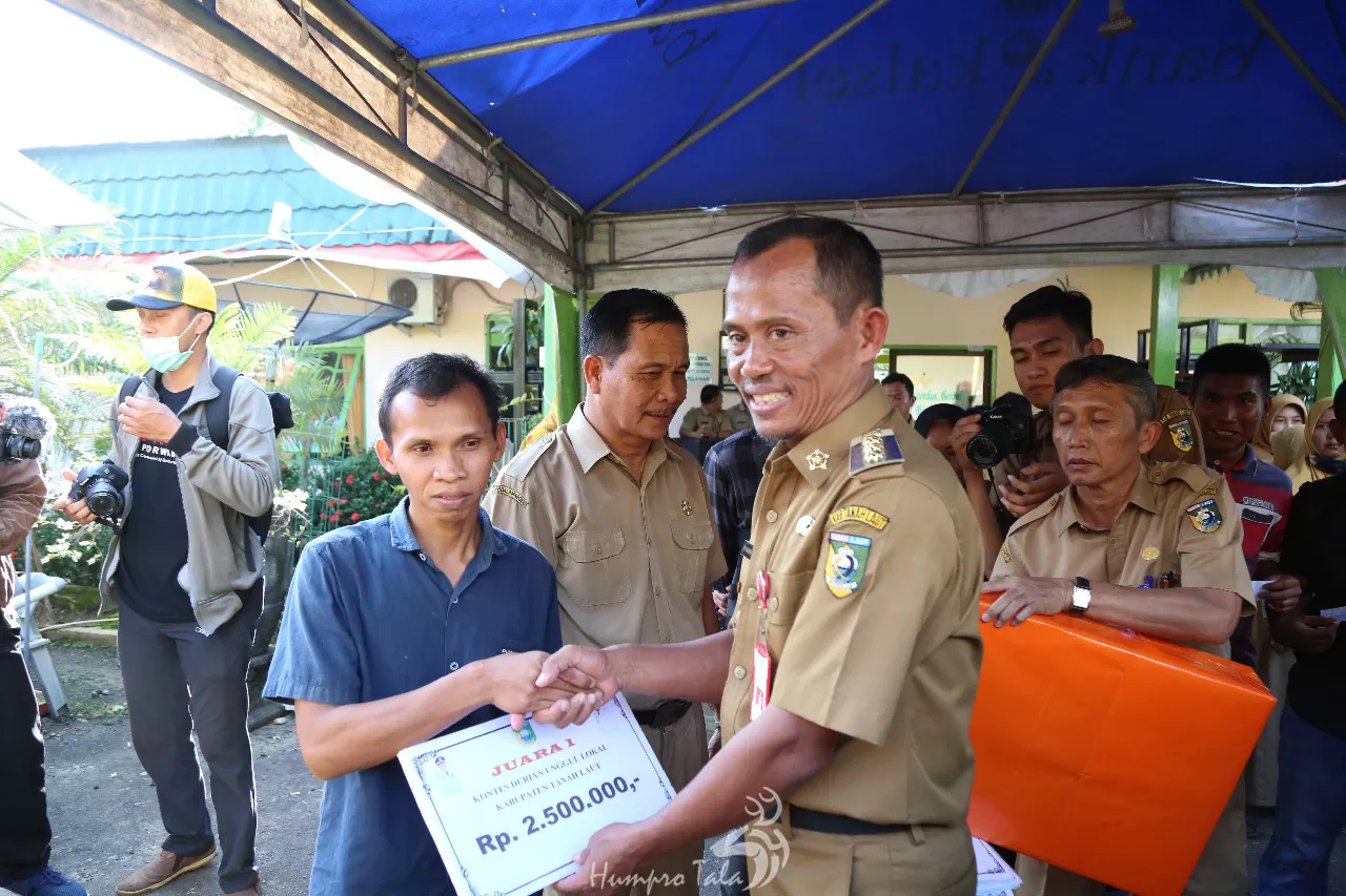JUARA: Bupati Tala Sukamta menyerahkan hadiah uang tunai dan bingkisan kepada Toniansyah sebagai juara pemilik durian tangkai panjang.