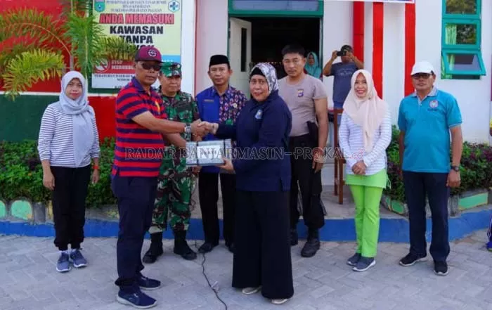 BUBUK ABATE: Kepala Dinas Kesehatan Tanbu H Setia Budi menyerahkan bubuk abate kepada Camat Kusan Hilir Dewi Murni. | Foto Diskominfo Tanbu For Radar Banjarmasin.