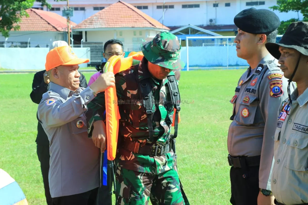 MOMEN: Bupati HSU H Abdul Wahid HK saat mengenakan Life Jacket atau jaket keselamatan pada perwakilan Satgas Penanganan Bencana HSU secara simbolis di Lapangan Pahlawan Amuntai Kamis (23/1). (Foto: Pemkab HSU untuk Radar Banjarmasin)