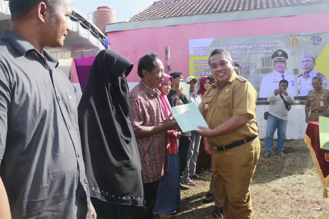 SERTIFIKAT: Walikota Banjarbaru H Nadjmi Adhani saat menyerahkan sertifikat PTSL (Pendaftaran Tanah Sistematis Lengkap) kepada ratusan warga Kelurahan Syamsudin Noor, Kecamatan Landasan Ulin, Selasa (4/2) tadi. | FOTO: HUMAS DAN PROTOKOL PEMKO BANJARBARU