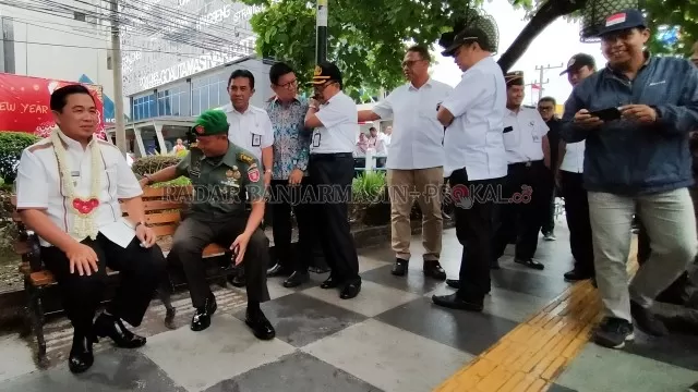 DUDUK SANTAI: Wali Kota Banjarmasin Ibnu Sina mencoba kursi yang terpasang di trotoar Jalan Ahmad Yani. Trotoar sepanjang tujuh kilometer telah dibangun di sisi kiri dan kanan jalan protokol tersebut.