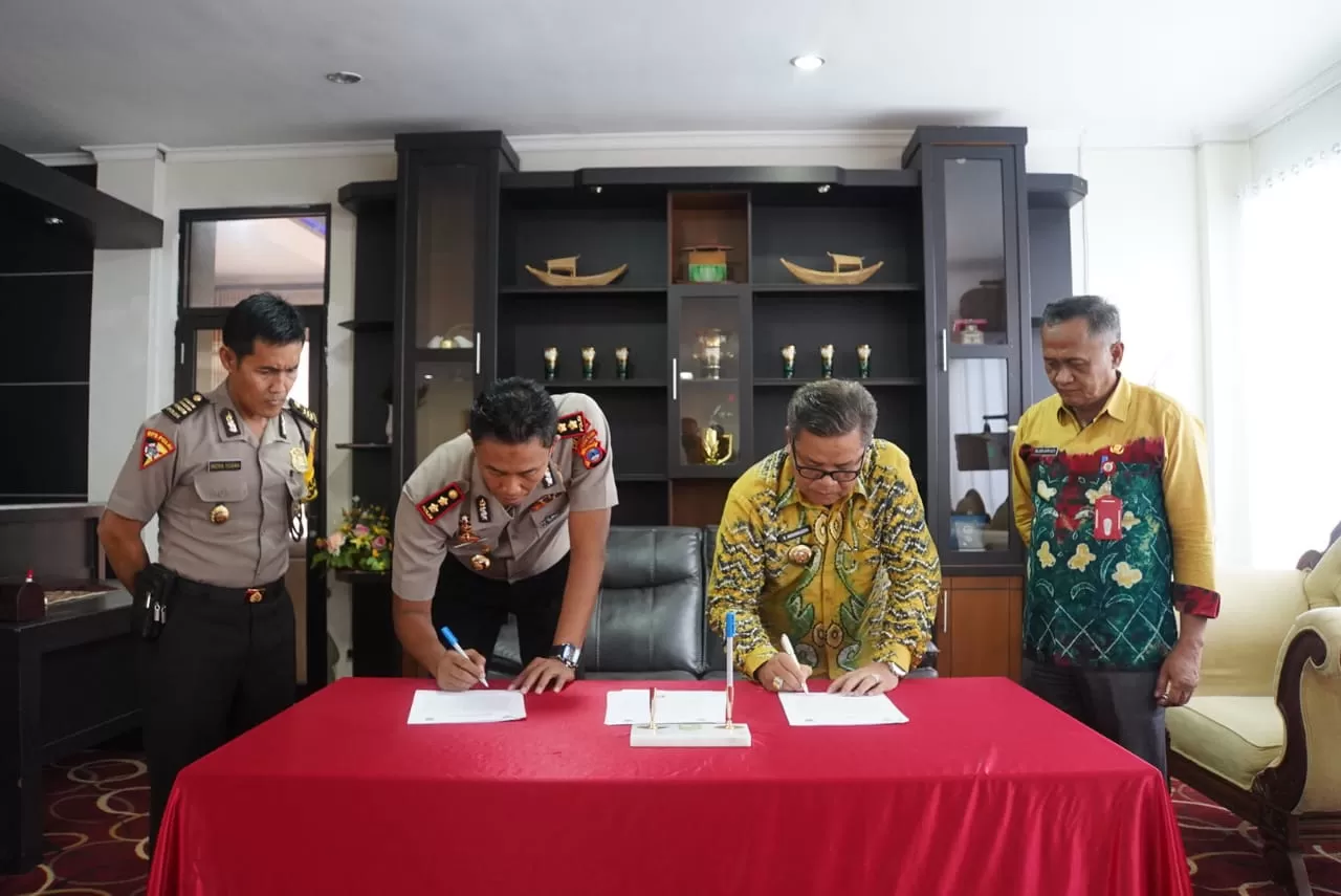 PENANDATANGANAN : Bupati Balangan Ansharuddin (kanan) bersama Kapolres Balangan AKBP Nur Khamid (kiri) saat menandatangani surat perjanjian hibah. | FOTO: WAHYUDI RADAR BANJARMASIN.