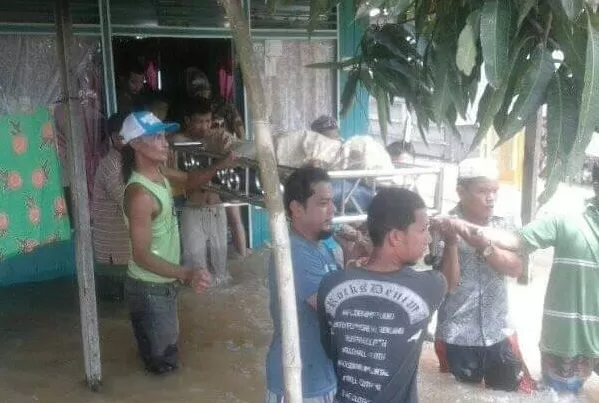 TRAGIS: Di tengah banjir melanda, warga Desa Murung Kenanga, Martapura, Kabupaten Banjar mengusung jenazah Rasyidi. Ia menjadi korban sengatan listrik, Senin (10/2).