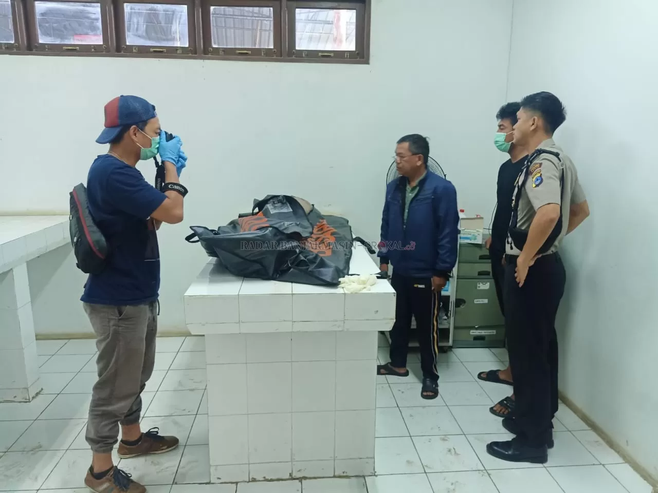 SATU KORBAN: Aparat kepolisian Polres Tapin melakukan identifikasi korban tenggelam di kamar jenazah RSUD Datu Sanggul Rantau. | Foto Rasidi Fadli/Radar Banjarmasin