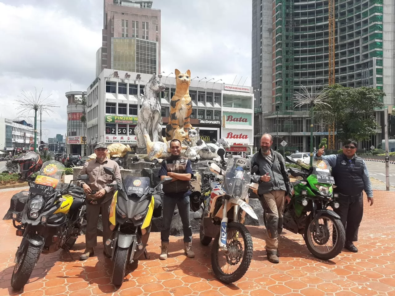 MASUK MALAYSIA: Tiga anggota Biker Sirath beserta David Simon Coulthard asal Australia berpose di depan patung kucing setiba di Kota Kuching, Serawak, Malaysia usai berkendara dari PLBN Entikong, Kalbar.