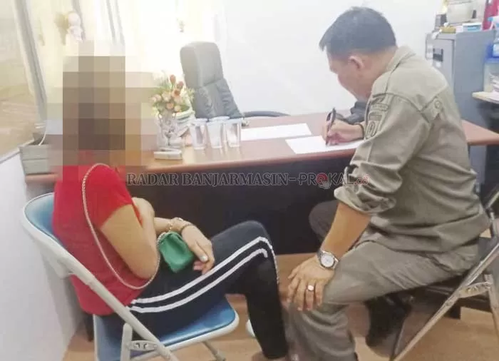 MASIH 14 TAHUN: Putri (kiri) diperiksa petugas Satpol PP Banjarbaru terkait bisnis prostitusi online yang dilakoninya bersama teman-temannya.