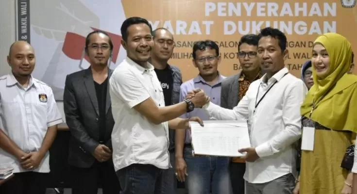KUMPULKAN BANYAK KTP: Edy Saifudin-Astina Zuraida saat menyerahkan berkas pencalonan perseorangan ke Komisi Pemilihan Umum (KPU) Banjarbaru, kemarin. | FOTO:  KPU BANJARBARU FOR RADAR BANJARMASIN