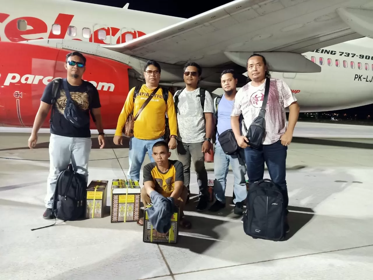 KEMBALI: Tersangka penipuan dan penggelapan, M Yusuf (jongkok) tiba di bandara Syamsudin Noor Banjarmasin di Banjarbaru pada Kamis (27/2) malam usai dirinya dijemput rim Resmob Polres Banjarbaru dari Sulawesi Selatan. | Foto: Polres Banjarbaru for Radar Banjarmasin