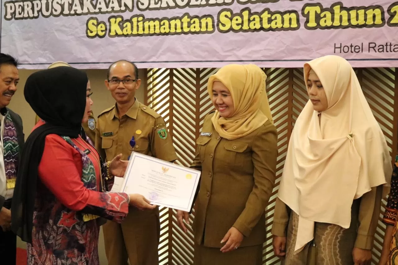 SELAMAT: Kepala MAN 2 Banjarmasin Naimah menerima sertifi kat akreditasi A dari Kepala Dinas Perpustakaan dan Arsip Kalsel Nurliani Dardie. | FOTO: MAN 2 BANJARMASIN FOR RADAR BANJARMASIN