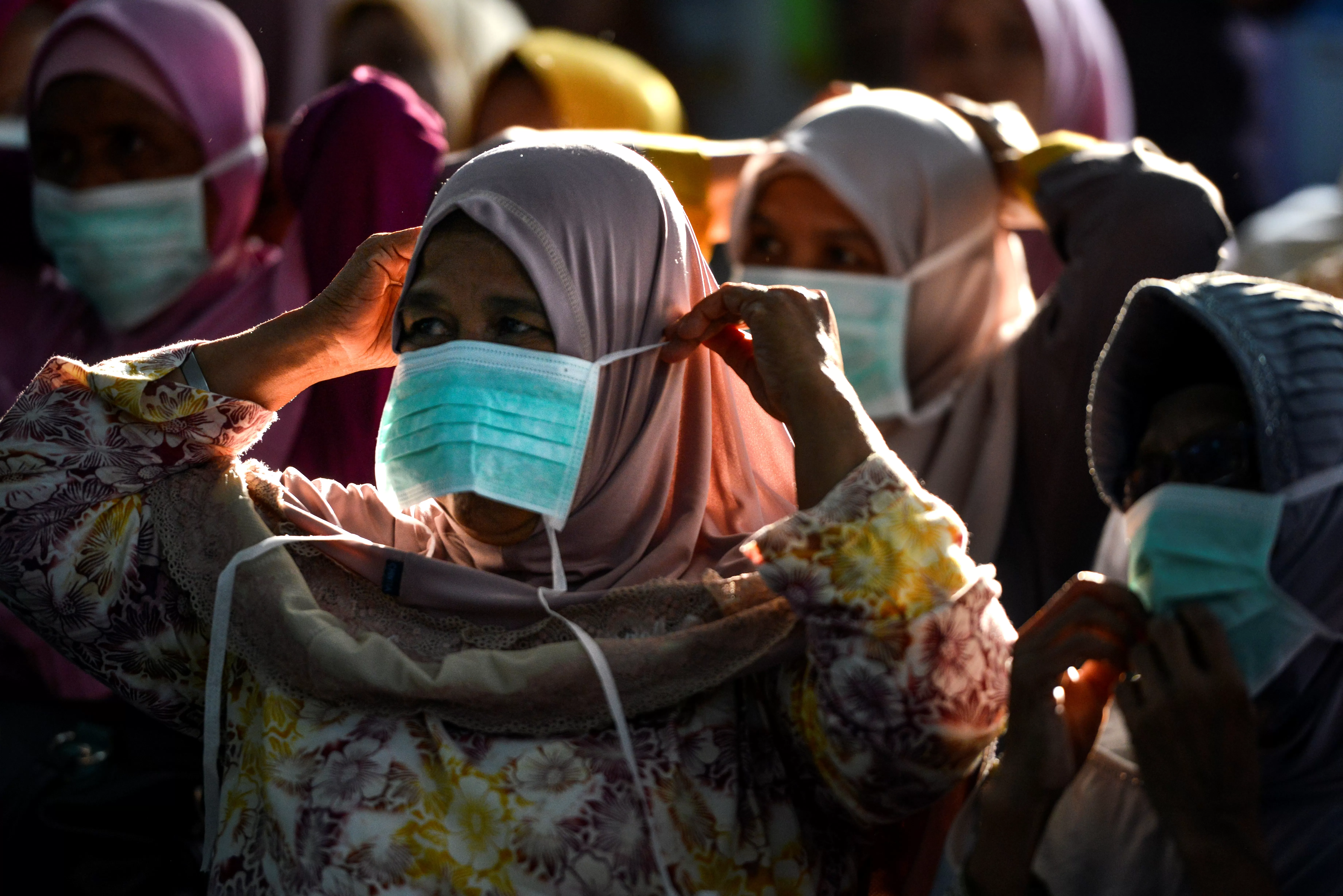 HILANG DI PASARAN: Para wanita mengenakan masker untuk mengantisipasi wabah corona. Masker menghilang di pasaran dalam beberapa pekan terakhir. | Foto: CHAIDEER MAHYUDDIN/AFP
