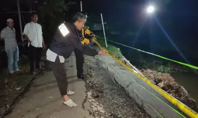 ANTISIPASI: Anggota Polsek Banjang memasang police line di lokasi jalan ambles di Desa Rantau Bujur Kecamatan Banjang.