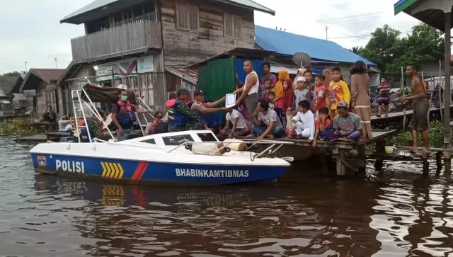 IMBAUAN: Menggunakan speedboat, aparat polisi dan TNI Kecamatan Candi Laras Selatan, menyampaikan maklumat antisipasi Covid-19.