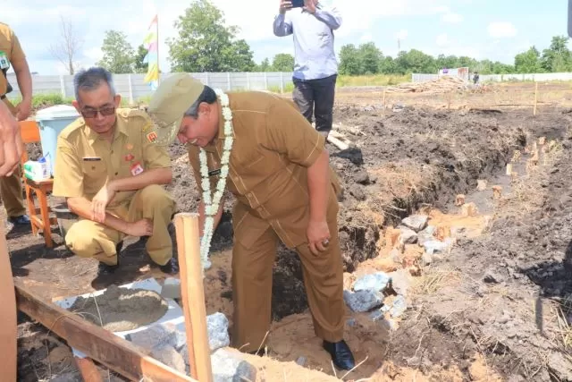 SEKOLAH BARU: Walikota Banjarbaru H Nadjmi Adhani, didampingi Kepala Dinas Pendidikan Kota Banjarbaru Dr H Muhammad Aswan, menghadiri peletakan batu pertama pembangunan Unit Sekolah Baru (USB) SDN 3 Landasan Ulin Utara, Senin (23/3) tadi. | FOTO: HUMAS DAN PROTOKOL PEMKO BANJARBARU