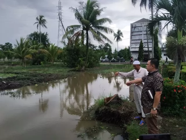BERMASALAH: Ketua Komisi III DPRD Banjarmasin, Muhammad Isnaini berdiri di tepi sungai. Di seberangnya akan dibangun perumahan yang dipersoalkan warga sekitar. | FOTO: KOMISI III DPRD BANJARMASIN FOR RADAR BANJARMASIN