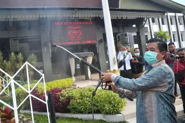 SEMPROT KENCANG: Wali Kota Banjarmasin Ibnu Sina menyemprotkan cairan disinfektan di depan Balai Kota di Jalan RE Martadinata. | FOTO: DISKOMINFO BANJARMASIN FOR RADAR BANJARMASIN