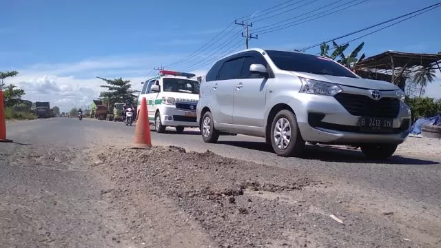 BAHAYA MENGINTAI: Warga Jalan Gubernur Subarjo RT 13 memasang traffic cone agar pengendara berhati-hati melintas di kawasan tersebut.