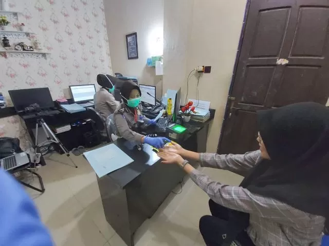 WAJIB STERIL: Personel pelayanan SIM Polres Banjarbaru memberikan cairan dari hand sanitizer kepada pemohon SIM sebelum melakukan proses foto dan pengambilan sidik jari. | Foto: Polres Banjarbaru for Radar Banjarmasin