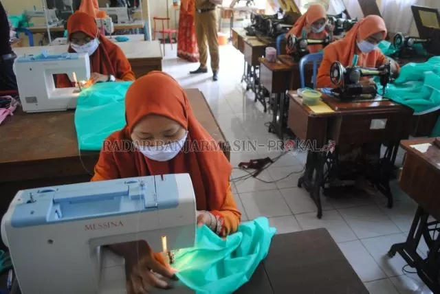 TELATEN: Para siswi SMKN 3 Banjarbaru saat ikut terlibat menjahit APD di sekolahnya, kemarin. Pembuatan APD ini merupakan inisiasi dari seorang dokter spesialis jantung bernama Gusti Rifansyah. | FOTO: SUTRISNO/RADAR BANJARMASIN