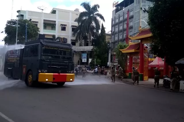 SEMPROT KELILING: Mobil water canon dibantu relawan BPK berkeliling sambil menyemprotkan cairan disinfektan di jalan protokol dan area publik.