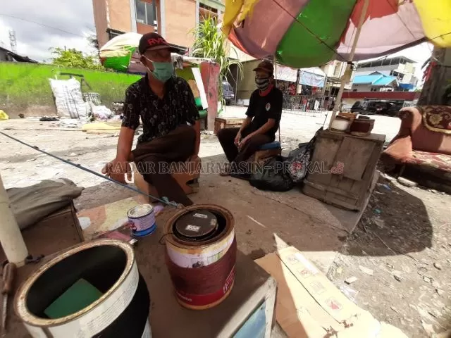 MENUNGGU PEMAKAI JASA: Kamaruddin dan Alek, dua penjahit sepatu yang biasa mangkal di pertigaan Jalan Kuripan. | Foto: Wahyu Ramadhan/Radar Banjarmasin