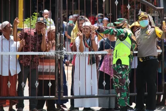 DIJAGA KETAT: Ratusan jemaah tertahan di luar pagar Masjid Al-Karomah, Martapura, kemarin. Mereka mencoba merangsek masuk tetapi ditahan oleh para aparat keamanan.   | Foto: M AMIN/RADAR BANJARMASIN