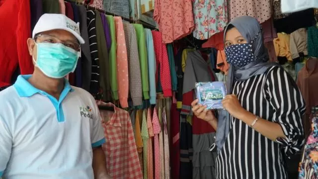 KEPEDULIAN: General Manager PLN UIW Kalselteng Sudirman membagikan masker kain yang merupakan Program CSR PLN Peduli kepada salah satu pedagang di Pasar Bauntung Banjarbaru sebagai pencegahan penyebaran wabah Covid-19, Selasa (21/4). | FOTO: PLN FOR RADAR BANJARMASIN.