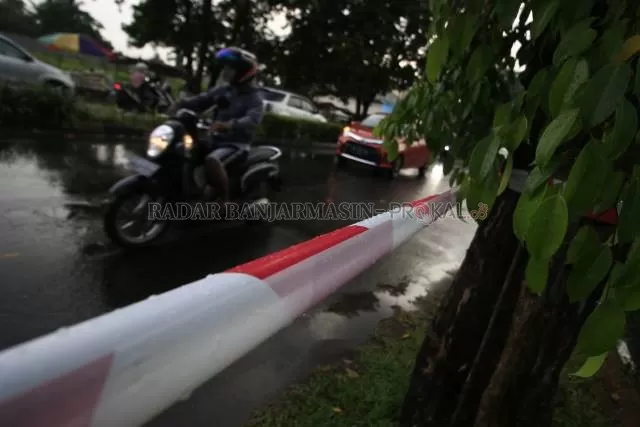 DIPASANG PETUGAS: Beberapa titik di jalan Panglima Batur Banjarbaru diikat tali sebagai tanda dan pembatas tidak diperkenankannya ada aktivitas jual beli karena situasi Pandemi Covid-19. | FOTO: MUHAMMAD RIFANI/RADAR BANJARMASIN