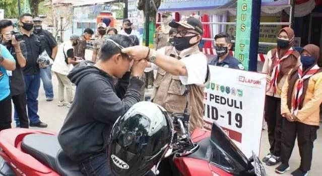 SOSIAL: Bupati Balangan Ansharuddin (kanan) saat turut serta membagikan masker kepada pengguna jalan. | FOTO: WAHYUDI/RADAR BANJARMASIN.
