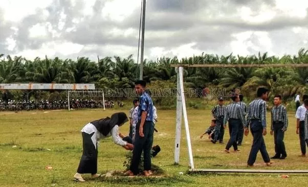 PEDALAMAN: Sabah Noor, guru di SMPN 1 Pulau Laut Barat memperbaiki tali bendera saat sekolah masih aktif. Para guru di Kabupaten Kotabaru belum menerima tunjangan sertifikasi dan tunjangan daerah bulan terakhir. | FOTO: ZALYAN SHODIQIN ABDI/RADAR BANJARMASIN
