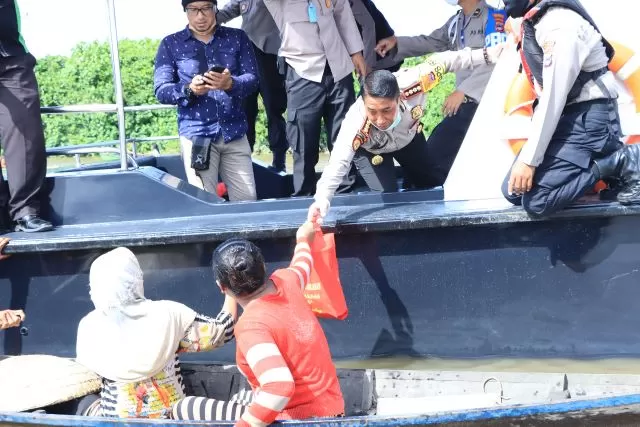 PEDULI: Kapolresta Banjarmasin Kombes Pol Rachmat Hendrawan membagikan bantuan sembako kepada warga di pesisir Sungai Martapura. | FOTO: HUMAS POLRESTA BANJARMASIN FOR RADAR BANJARMASIN
