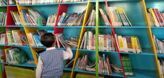 JENDELA DUNIA: Seorang anak memilih buku di Kids Library. Fasilitas ini tersedia di Perpus Pal Nam milik Dispersip Kalsel. | FOTO: ENDANG SYARIFUDDIN/RADAR BANJARMASIN