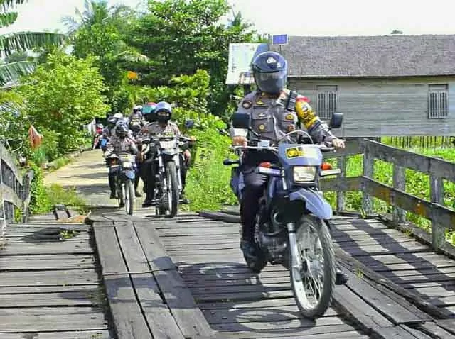 TERPENCIL: Kapolres HSU, AKBP Pipit Subiyanto SIK menuju Desa Mawar Sari dan Pinang Kara yang hanya bisa diakses menggunakan kendaraan roda dua untuk berbagai sembako.
